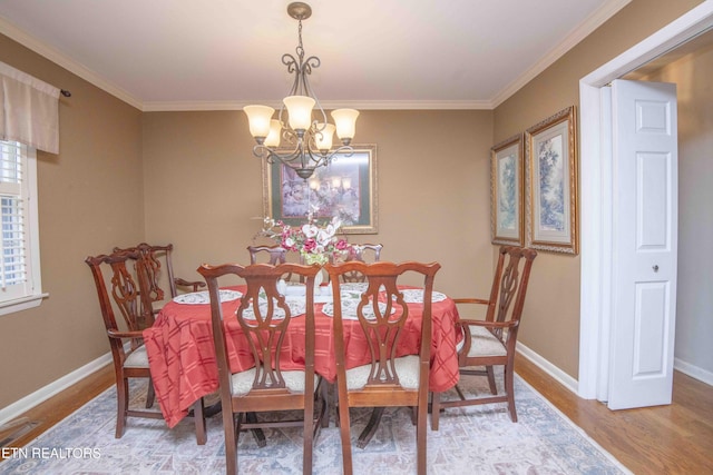 dining room featuring hardwood / wood-style floors, crown molding, and a chandelier