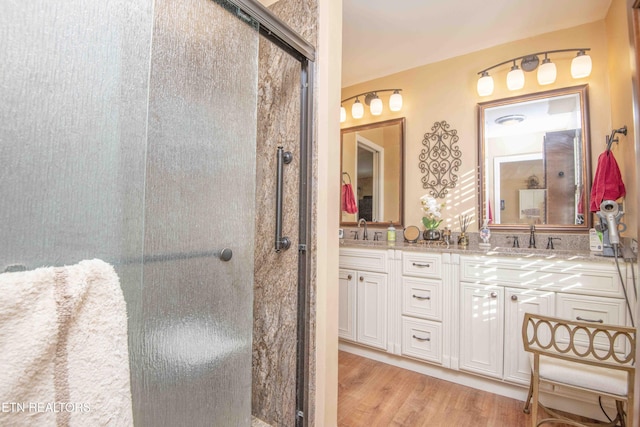 bathroom with vanity, wood-type flooring, and a shower with door