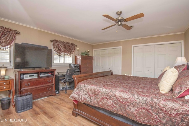 bedroom featuring multiple closets, ceiling fan, light hardwood / wood-style flooring, and ornamental molding