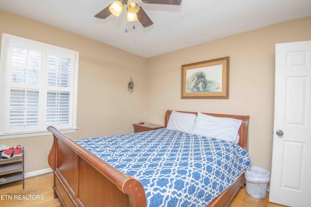 bedroom with ceiling fan, light wood-type flooring, and multiple windows