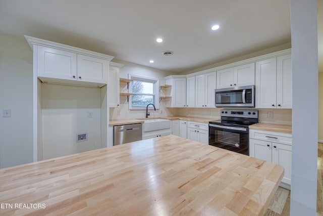 kitchen featuring wood counters, white cabinetry, sink, and appliances with stainless steel finishes