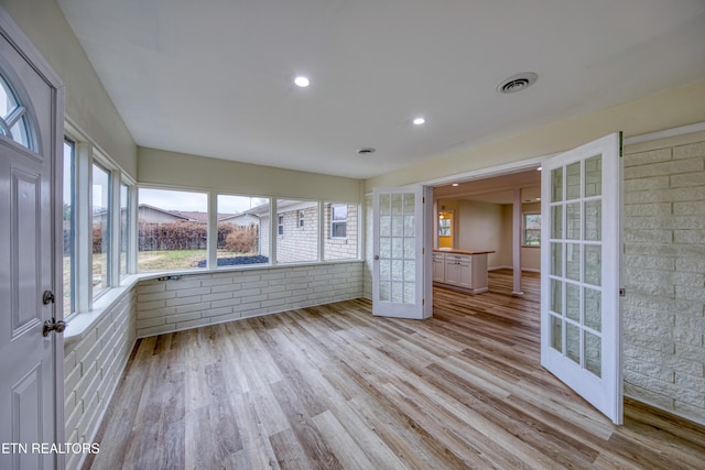 unfurnished sunroom with french doors and a healthy amount of sunlight