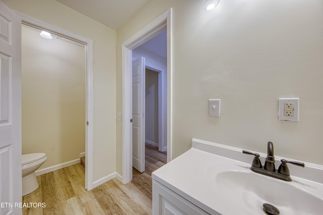 bathroom featuring toilet, vanity, and hardwood / wood-style flooring