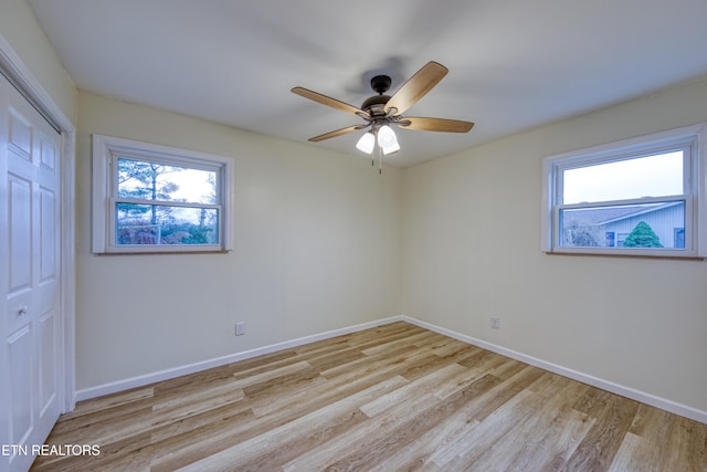 empty room with ceiling fan, light hardwood / wood-style floors, and a wealth of natural light