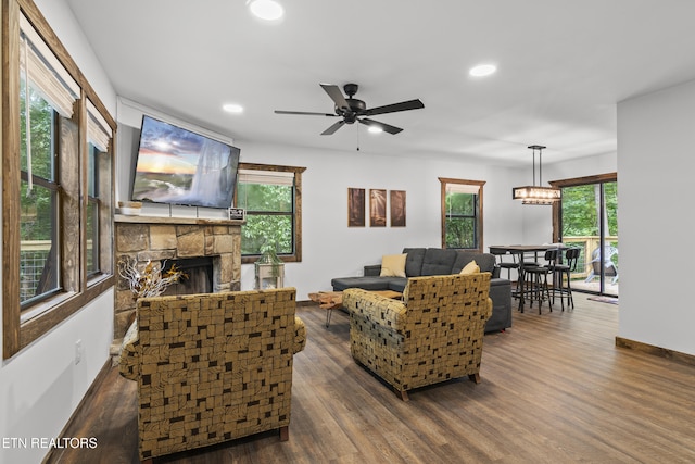 living room featuring a fireplace, dark hardwood / wood-style flooring, and a wealth of natural light