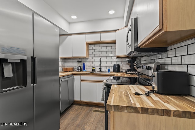 kitchen featuring butcher block counters, white cabinetry, and stainless steel appliances