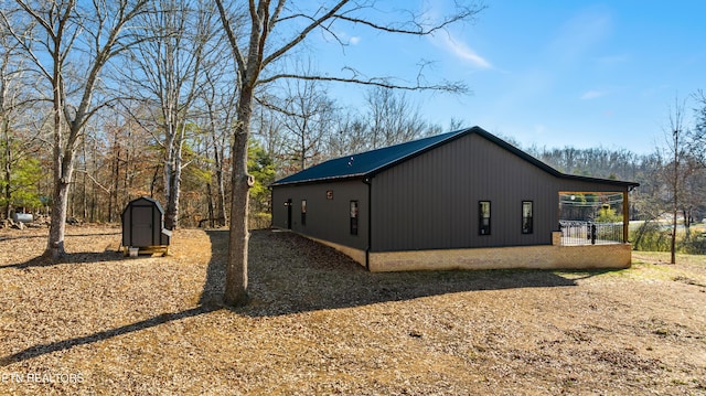 view of side of home featuring a storage shed