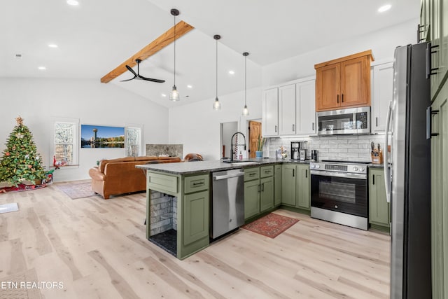 kitchen with appliances with stainless steel finishes, tasteful backsplash, sink, lofted ceiling with beams, and green cabinetry