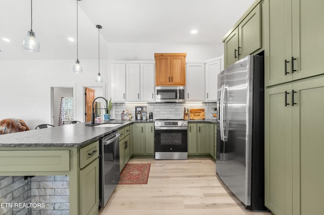 kitchen with pendant lighting, sink, appliances with stainless steel finishes, and green cabinetry