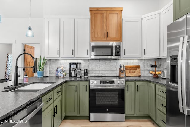 kitchen with white cabinets, pendant lighting, sink, and appliances with stainless steel finishes