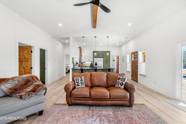 living room featuring vaulted ceiling with beams, light hardwood / wood-style floors, and ceiling fan