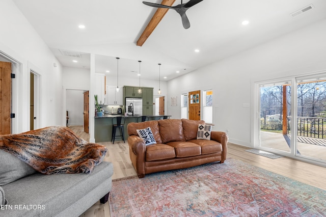 living room featuring vaulted ceiling with beams, light hardwood / wood-style flooring, and ceiling fan