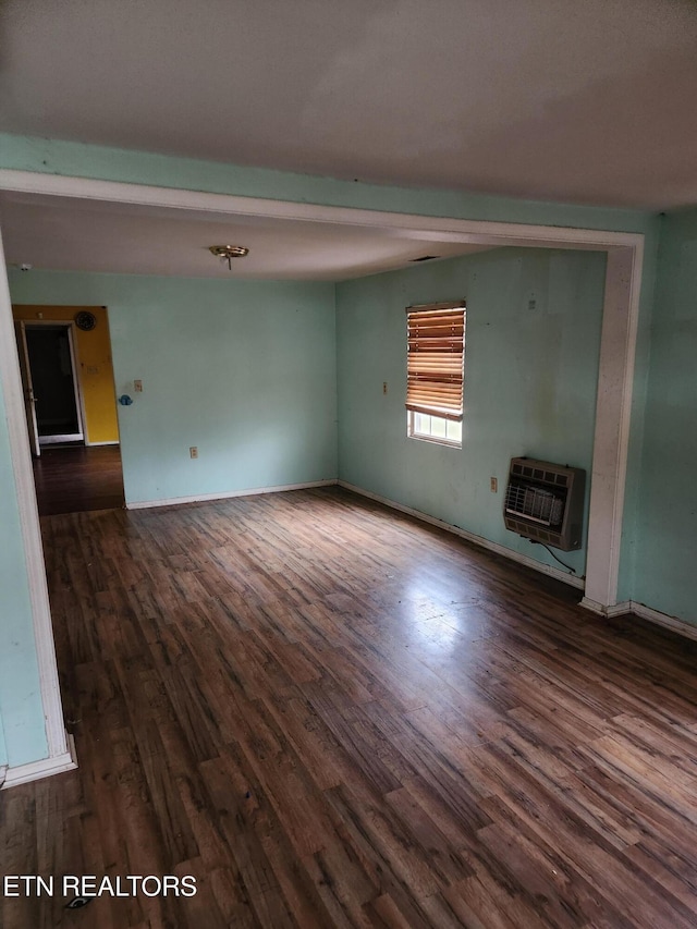 unfurnished living room featuring dark hardwood / wood-style floors and heating unit