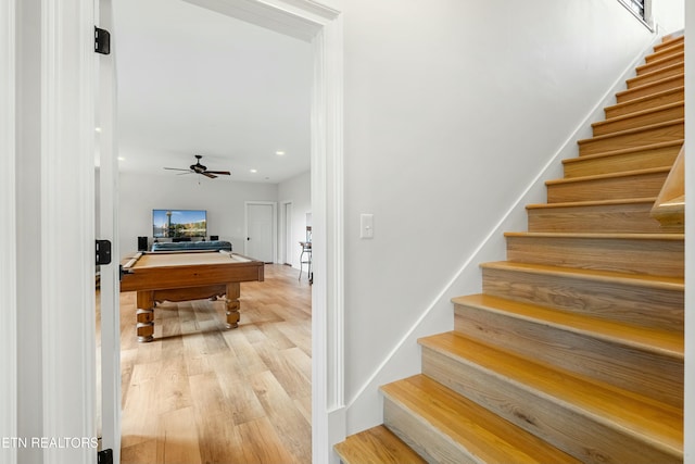 stairway featuring ceiling fan and hardwood / wood-style flooring