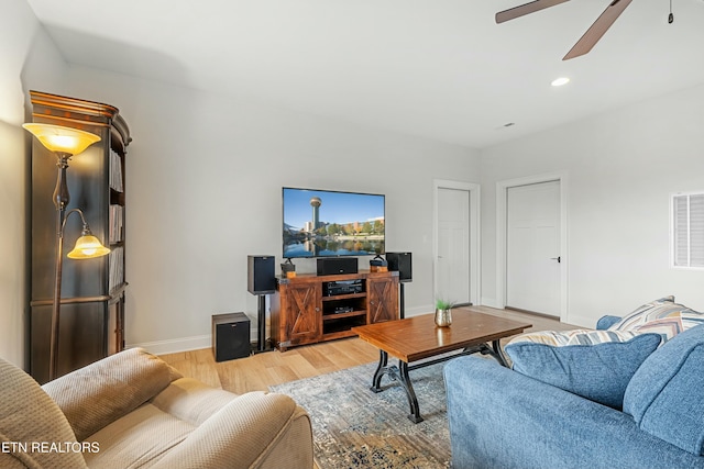 living room with ceiling fan and light hardwood / wood-style flooring