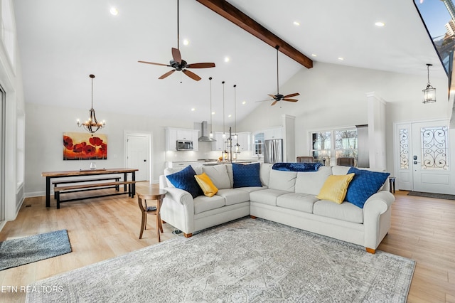 living room featuring beamed ceiling, ceiling fan with notable chandelier, light hardwood / wood-style floors, and high vaulted ceiling