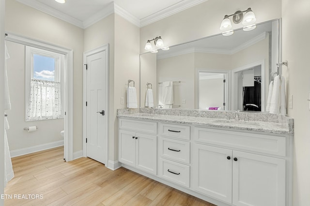 bathroom featuring wood-type flooring, vanity, toilet, and crown molding