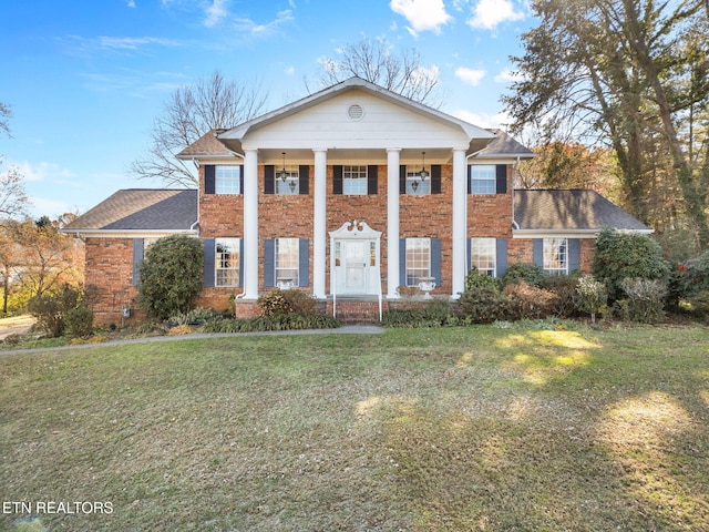 neoclassical / greek revival house featuring a front yard