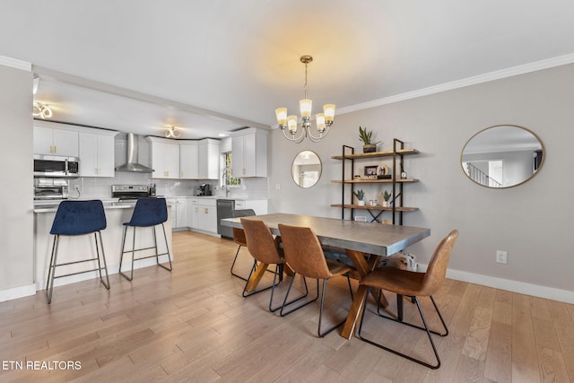 dining area with ornamental molding, a chandelier, and light wood-type flooring