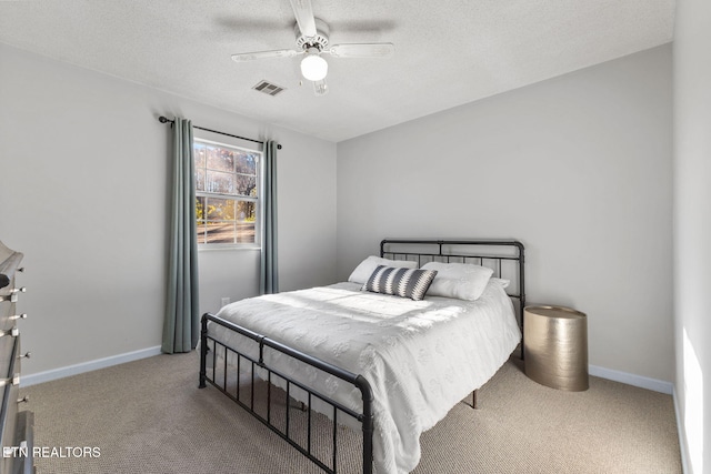 carpeted bedroom featuring a textured ceiling and ceiling fan