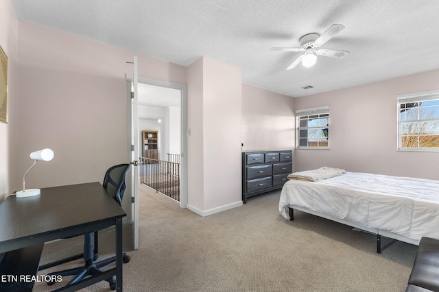 carpeted bedroom with multiple windows, a textured ceiling, and ceiling fan