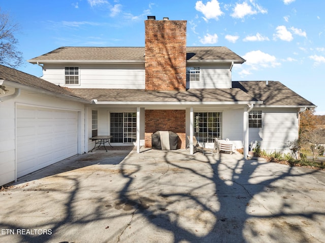 back of property with a patio and a garage