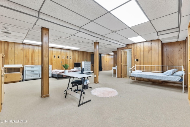 basement featuring a drop ceiling and light colored carpet