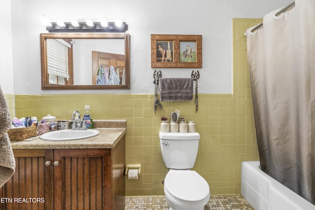 bathroom featuring a wainscoted wall, tile walls, shower / bath combination with curtain, toilet, and vanity