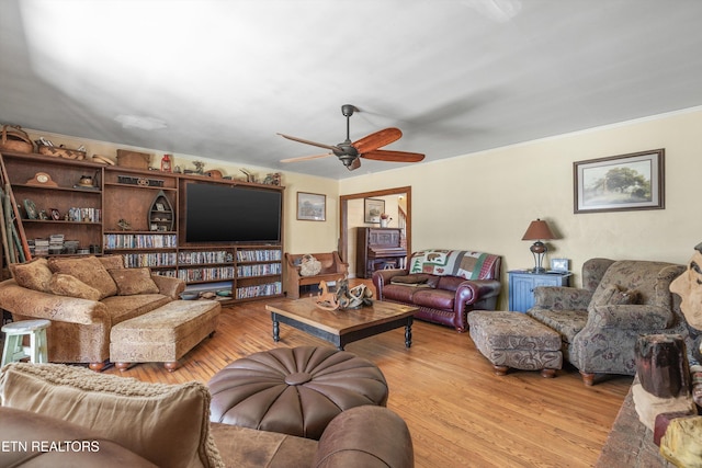 living room featuring ceiling fan, wood finished floors, and crown molding