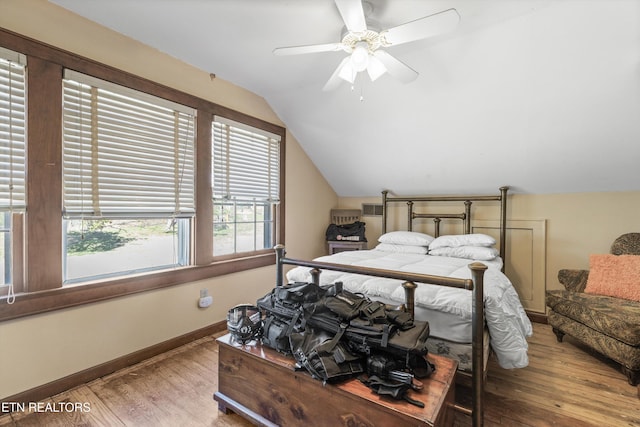 bedroom with lofted ceiling, a ceiling fan, baseboards, and wood finished floors