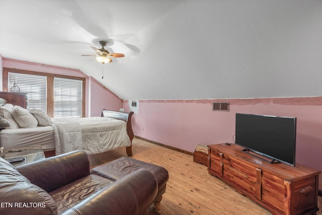 bedroom featuring visible vents, baseboards, lofted ceiling, ceiling fan, and light wood-style floors