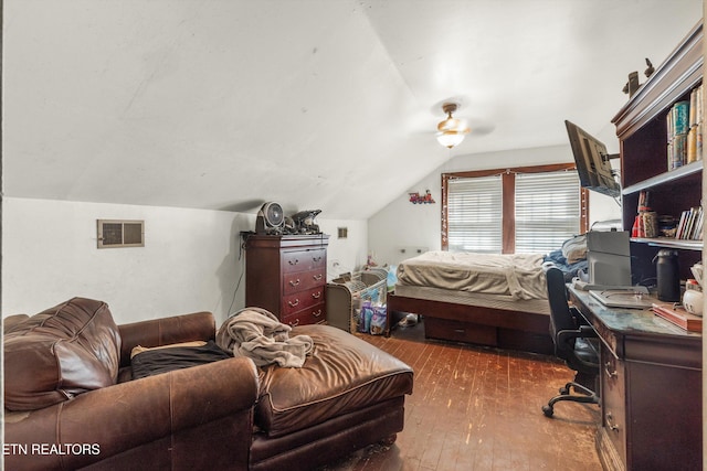 bedroom with hardwood / wood-style flooring, visible vents, and vaulted ceiling