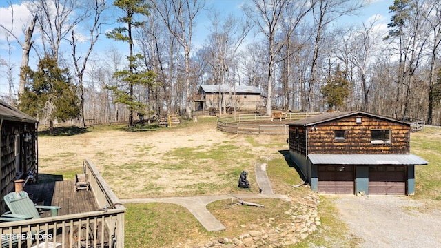 view of yard with a garage, driveway, and an outdoor structure