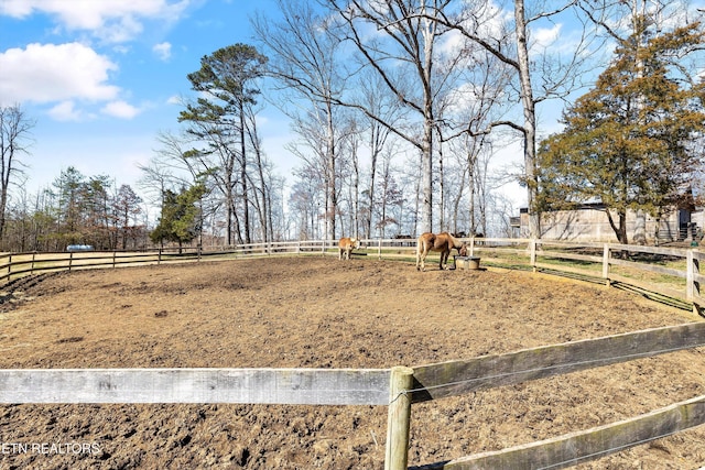 view of yard with fence and a rural view