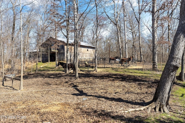 view of yard with a rural view, an exterior structure, and an outdoor structure