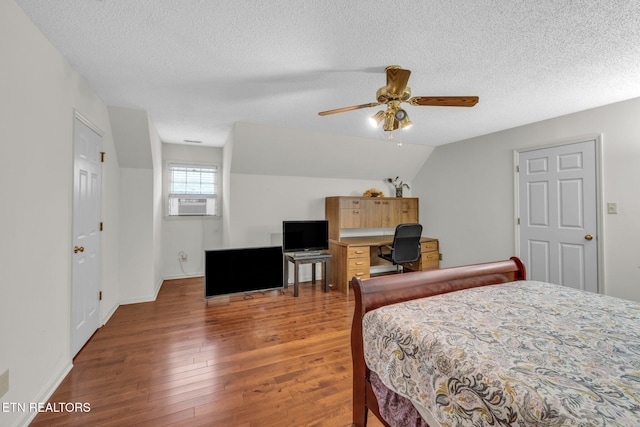 bedroom featuring ceiling fan, dark hardwood / wood-style floors, cooling unit, a textured ceiling, and vaulted ceiling