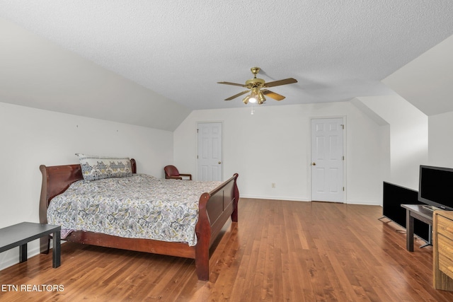 bedroom featuring hardwood / wood-style floors, ceiling fan, a textured ceiling, and vaulted ceiling