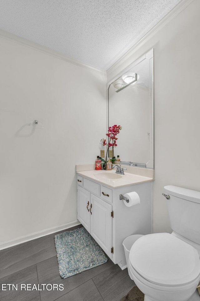 bathroom with crown molding, vanity, a textured ceiling, and toilet