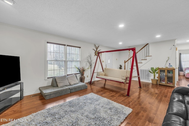 living room featuring wood-type flooring and a textured ceiling