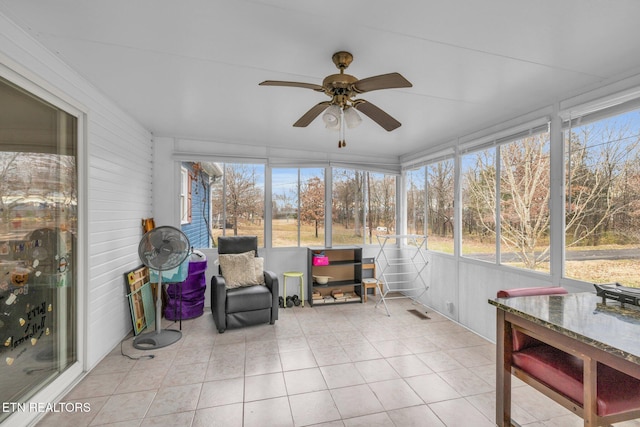 unfurnished sunroom featuring ceiling fan