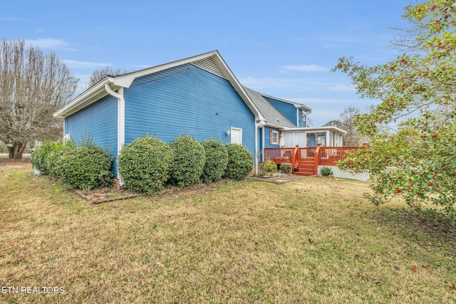 rear view of property with a lawn and a deck