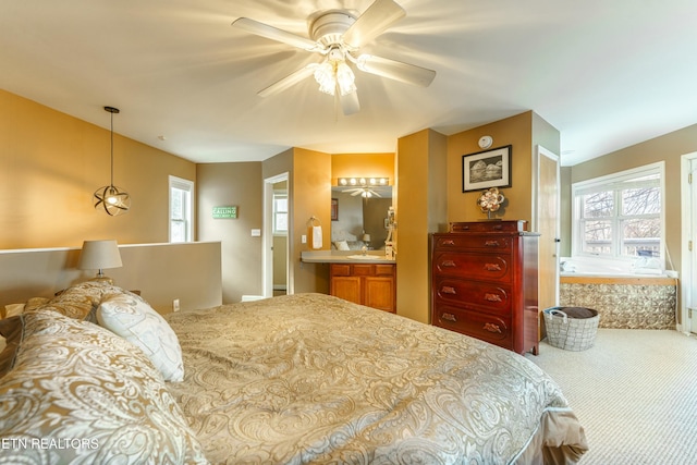 carpeted bedroom with ceiling fan, multiple windows, and ensuite bathroom