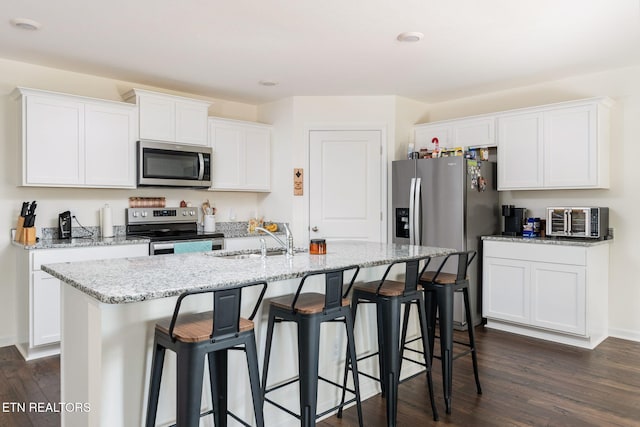 kitchen with a center island with sink, sink, white cabinetry, and stainless steel appliances