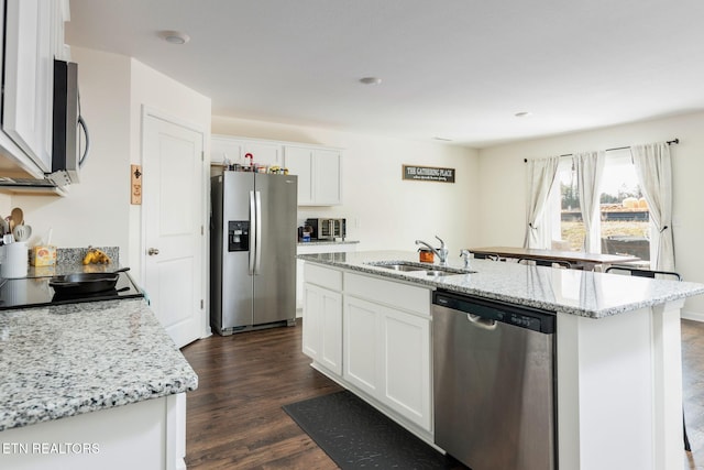 kitchen with dark hardwood / wood-style flooring, stainless steel appliances, a kitchen island with sink, sink, and white cabinets