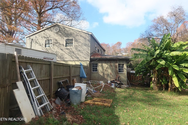 rear view of house with a lawn and a storage shed