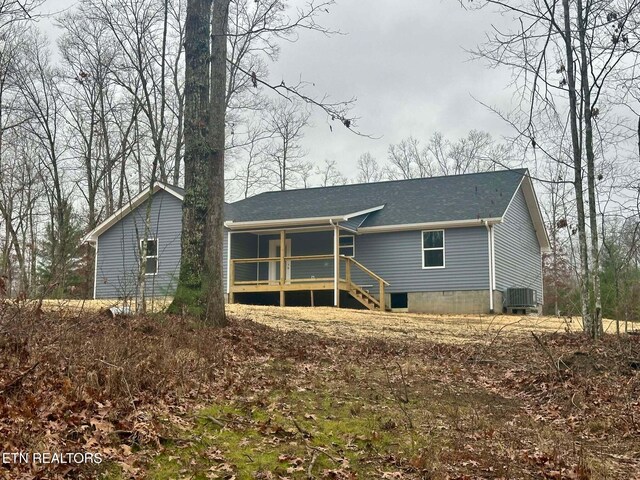 rear view of property with a sunroom and central air condition unit