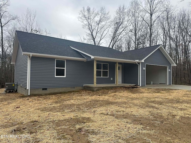 view of front facade with covered porch, a garage, and central AC unit