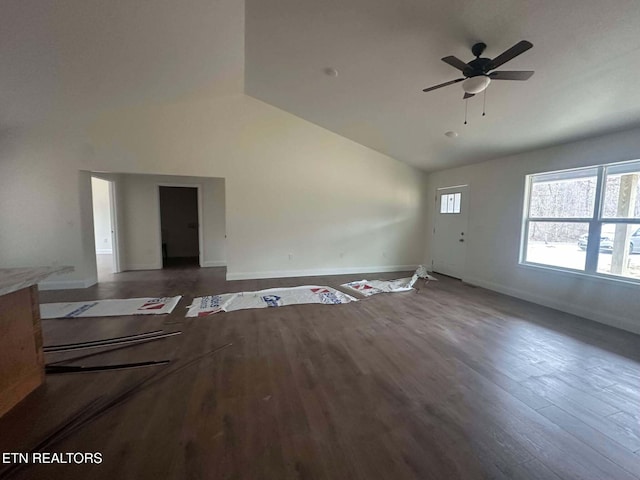 unfurnished living room featuring dark hardwood / wood-style flooring, vaulted ceiling, and ceiling fan