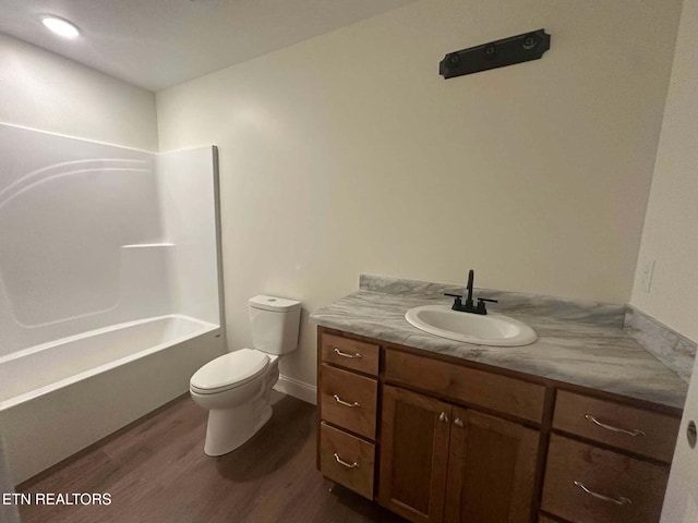 full bathroom with hardwood / wood-style flooring, vanity,  shower combination, and toilet