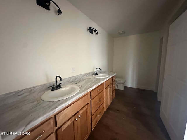 bathroom with hardwood / wood-style floors, vanity, and toilet